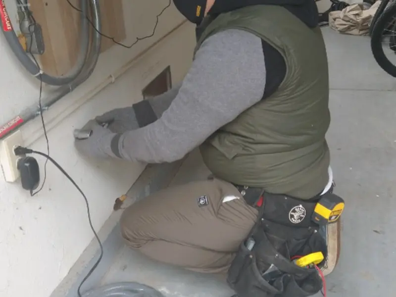 Electrician performing outlet wiring in a Melrose Park garage